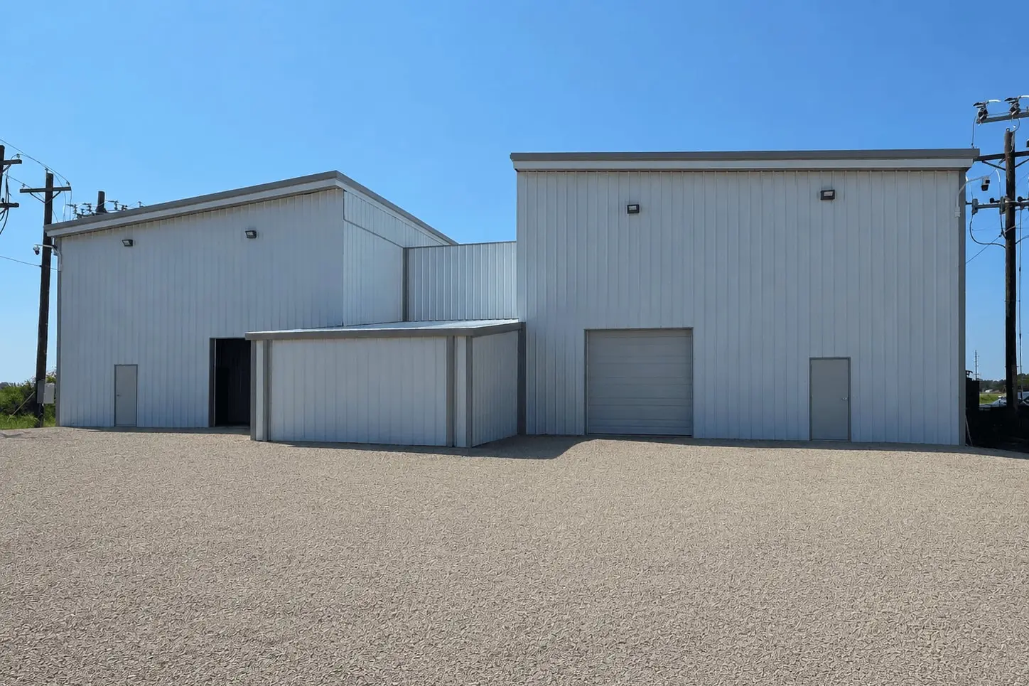 AAIM's Minnesota 1 data center in Blue Earth: two white metal buildings on a gravel apron under a clear sky