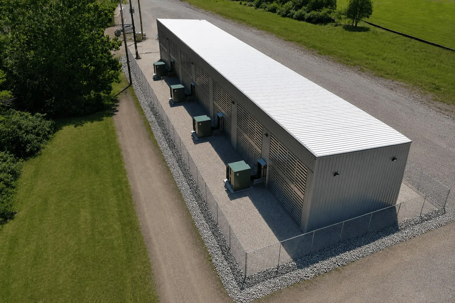 Aerial view of the Missouri facility: a long louvered building with its line of transformers inside a fenced gravel compound